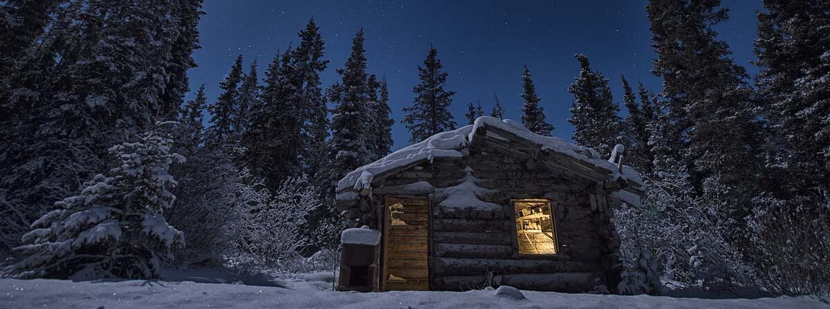 Image of Cabin in snowy winter setting at night