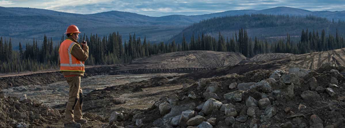 Image of mining site with worker overlooking the area